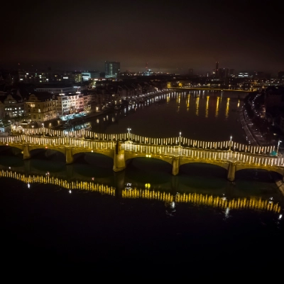 Luftaufnahme der weihnachtlich beleuchteten mittleren Brücke in Basel