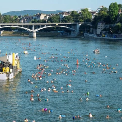 Menschen schwimmen am alljährlichen Rheinschwimmen zusammen im Rhein.