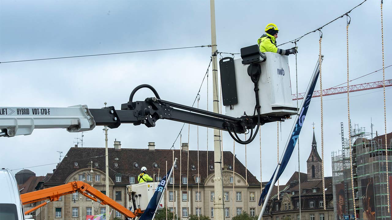 Mann auf Hebekran wechselt in Basel die Brückenbeleuchtung aus
