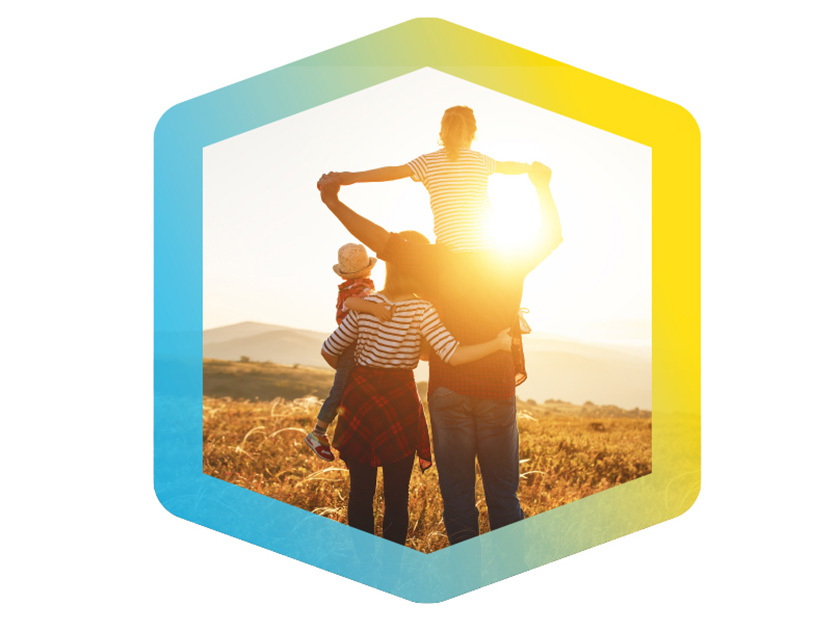 Familie blickt einem Sonnenuntergang entgegen