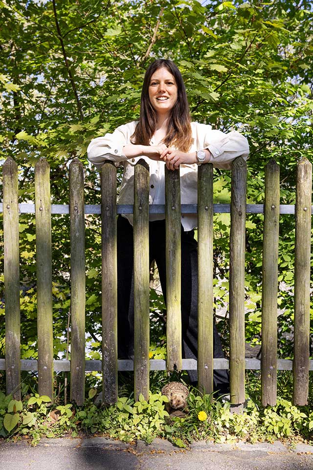 Wildtierbiologin Julia Felber steht hinter einem Gartenzaun