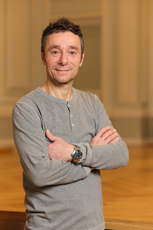 Gian-Petro Crosilla steht in einem warm beleuchteten Raum der Musikakademie.