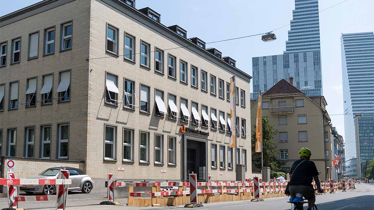 Der Hauptsitz der Warteck Invest AG im Kleinbasel. Im Vordergrund sieht man die neue Fernwärmeleitung, im Hintergrund den Roche Tower.
