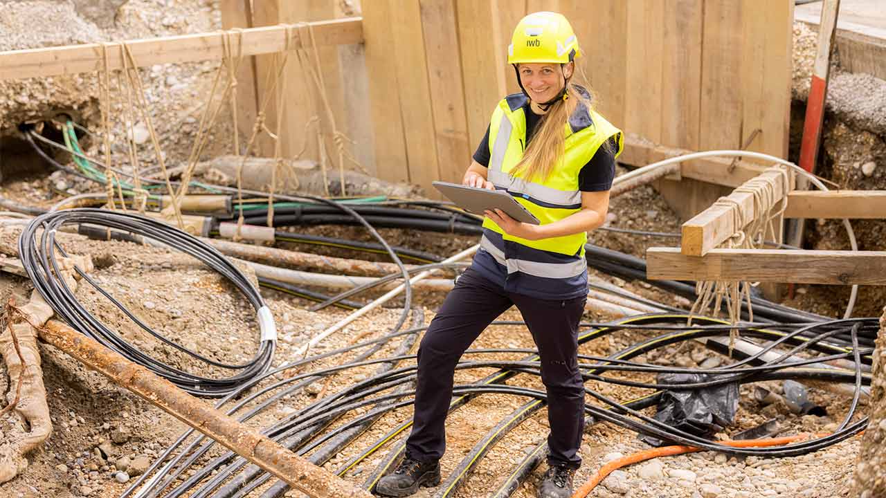 Frau in Arbeitskleidung steht in einer Baustelle