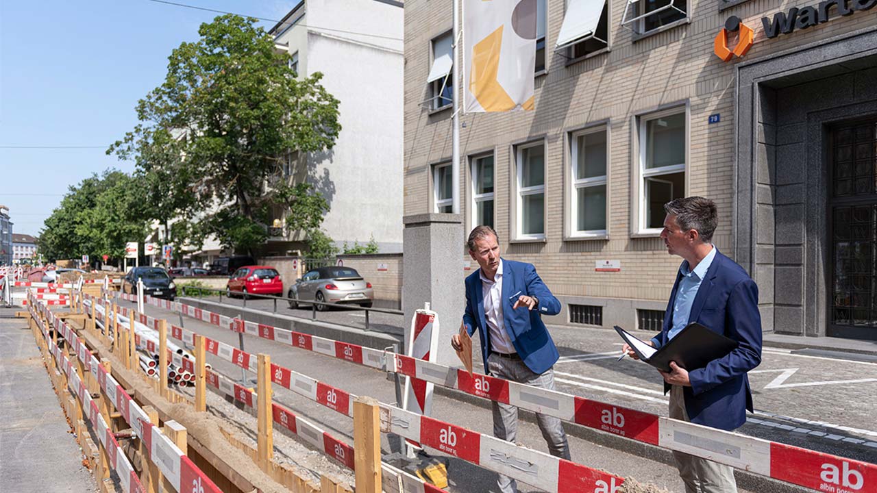 Daniel Petitjean von Warteck Invest AG und Andreas Speck von IWB begutachten gemeinsam die Baustelle für den Fernwärmeanschluss vor dem Hauptsitz im Kleinbasel.