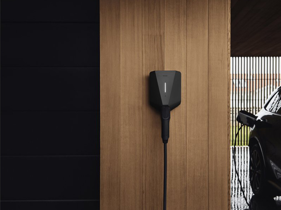 Schwarze Ladestation easee Charge up hängt in einer Garage an der Wand